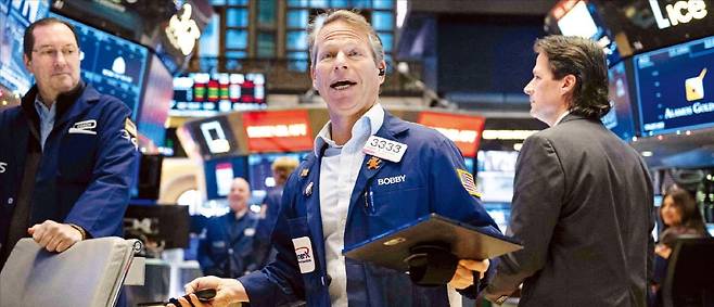 18일(현지시간) 인공지능(AI) 반도체 관련 주요 기업의 호실적과 주가 전망치 상향에 힘입어 미국 등 글로벌 증시에서 기술주가 급등했다. 지난 3일 미국 뉴욕증권거래소(NYSE)에서 트레이더들이 전광판을 보고 있다. /AFP연합뉴스