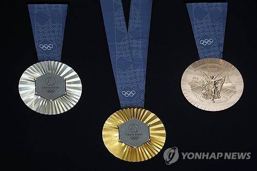 (파리 AP=연합뉴스) 파리올림픽조직위원회가 8일(현지시간) 공개한 올림픽 메달 디자인. 메달 뒷면에 에펠탑의 실제 철 조각이 박혀 있다.