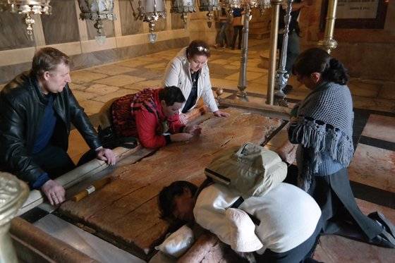 예루살렘 골고다 언덕에 있는 성묘 교회. 숨진 예수를 십자가에서 내려 눕혔다는 돌판 앞에서 순례객 이 기도하고 있다. 백성호 기자