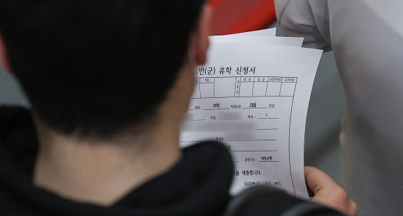 휴학 신청서 든 의대생 - 20일 한 대학병원에서 의대생이 휴학 신청서 여러 장을 들고 의사 선배를 따라가고 있다. 연합뉴스