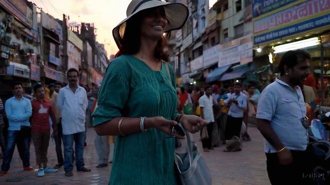 ‘녹색 옷과 모자를 쓴 여성이 아름다운 일몰 시간에 뭄바이를 즐겁게 걷고 있다’는 지시문으로 생성된 동영상 장면. 오픈에이아이 누리집 갈무리
