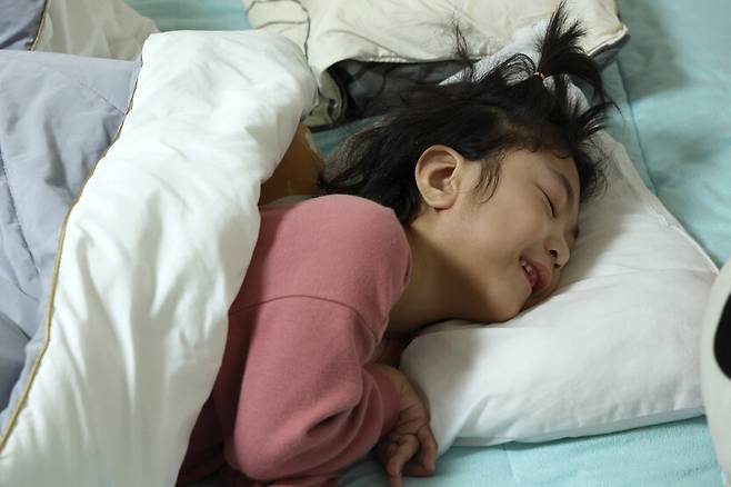 민정이가 2월23일 오후 침대에서 쉬는 중에 머리맡 휴대전화에서 흘러나오는 엄마, 아빠의 목소리를 들으며 웃고 있다. 김영원 기자 forever@hani.co.kr