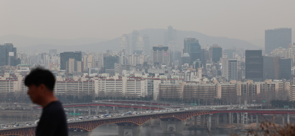 신규 아파트 분양가가 오르면서 전국 아파트 분양권 거래량이 증가하고 있다. 사진은 5일 한 시민이 서울 아파트 밀집 지역 배경 앞으로 지나는 모습. 뉴시스