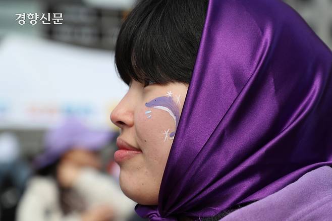 세계 여성의 날인 8일 서울 중구 청계광장에서 열린 제39회 한국여성대회 참가자가 보라색으로 페이스 페인팅을 하고 있다.