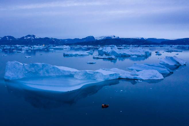한 보트가 그린란드 동부 쿨루수크 타운 부근의 녹은 빙하 옆을 지나가는 모습./연합뉴스