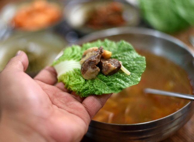 국밥의 고기를 쌈으로 싸먹는 ‘궁물촌’의 국밥.