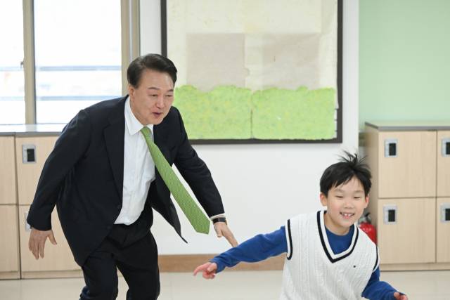 ▲윤석열 대통령이 3월 21일 강원도 원주시 명륜초등학교의 늘봄학교 '초1 맞춤형 프로그램'에 참여해 어린이들과 술래잡기 놀이를 함께하고 있다. ⓒ연합뉴스
