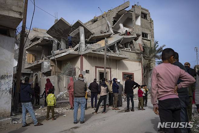 [라파=AP/뉴시스] 27일(현지시각) 가자지구 라파에서 팔레스타인 주민들이 이스라엘군의 공습으로 파괴된 건물 주변에 모여들고 있다. 2024.03.28.
