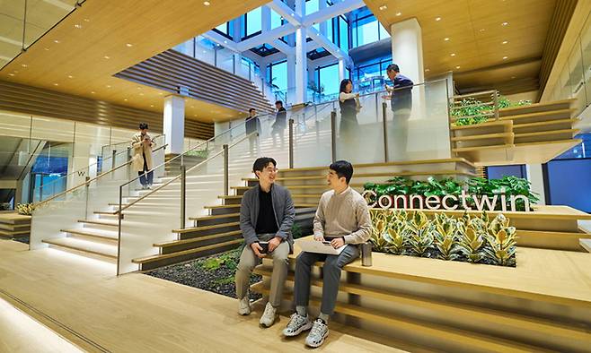 LG 직원들이 LG트윈타워 저층부 공용공간에서 대화를 나누는 모습. 1층 로비와 지하 1층을 연결하는 이 공간은 임직원 공모를 통해 ‘그랑밸리’로 명명됐다. LG 제공