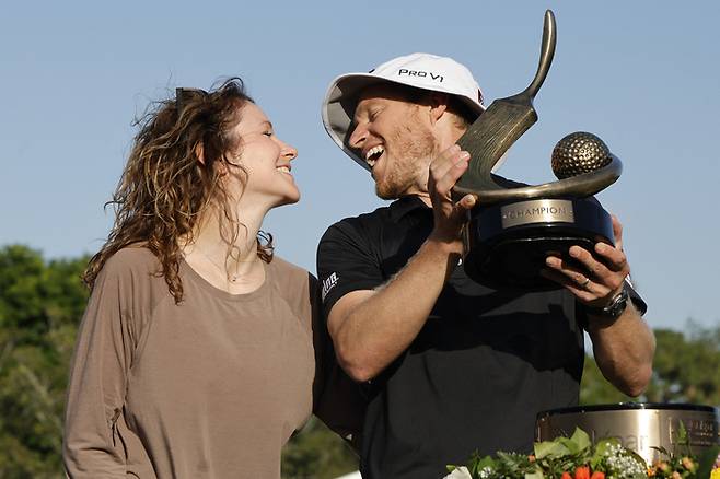 피터 맬너티가 지난 25일 미국 플로리다주 팜 하버의 이니스브룩 코퍼헤드 코스에서 열린 PGA 투어 발스파 챔피언십에서 9년 만에 우승한 뒤 트로피를 들고 아내와 한껏 기뻐하고 있다.  팜하버｜AP 연합뉴스