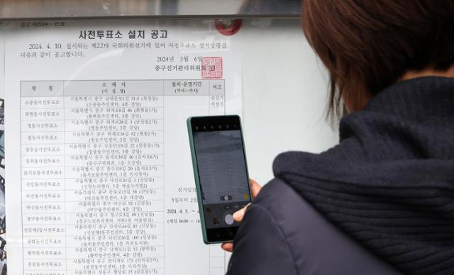 25일 서울 중구 을지로동 주민센터에 게시된 22대 국회의원 선거 사전투표소 설치 공고문을 한 시민이 촬영하고 있다. 뉴스1