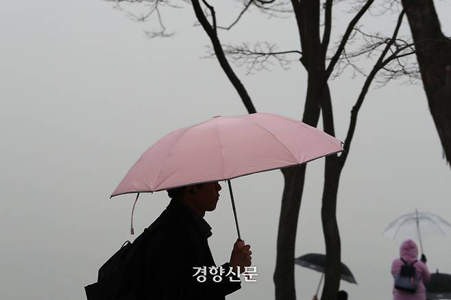 내몽골고원으로부터 황사가 유입되며 전국 대부분 지역이 미세먼지 농도 나쁨 수준을 보인 29일 한 시민이 서울 용산구 남산타워에서 황사비를 피해 우산을 쓰고 있다.  한수빈 기자