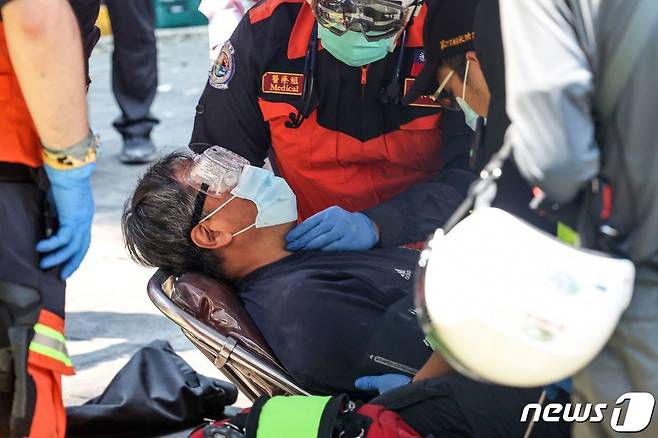 무너진 건물에서 구조된 생존자가 병원으로 이송되고 있다. ⓒ AFP=뉴스1 ⓒ News1 정지윤 기자