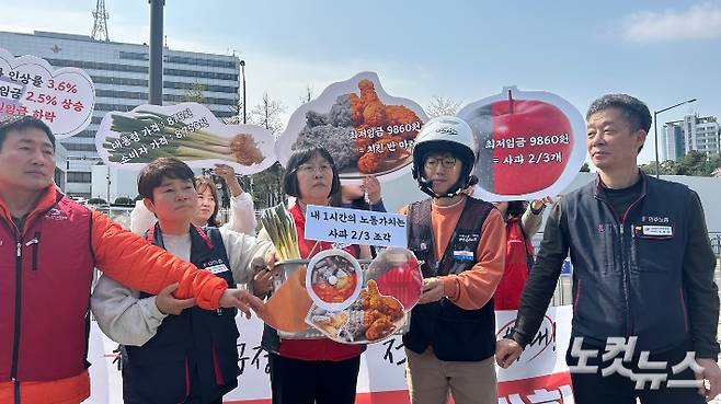 민주노총이 4일 오전 서울 용산구 대통령실 앞에서 최저임금(9860원)으로 구매할 수 있는 음식 모양의 피켓을 장바구니에 담는 퍼포먼스를 하고 있다. 박인 수습기자