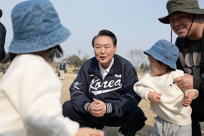 윤석열 대통령이 6일 서울 용산어린이정원 잔디마당을 찾아 한 가족과 대화하고 있다. 연합뉴스