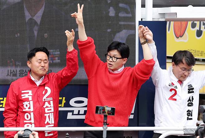 한동훈 국민의힘 비상대책위원장이 5일 오전 인천 미추홀구 토지금고시장 앞에서 열린 ‘국민의힘으로 동미추홀살리기' 지원유세에서 심재돈(왼쪽) 동구미추홀구갑, 윤상현 동구미추홀구을 후보의 지지를 호소하고 있다. 뉴시스