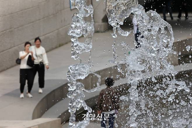 따뜻한 날씨가 이어진 8일 서울 중구 청계광장 일대에서 시민들이 시원하게 뿜어지는 분수 곁을 걷고 있다.