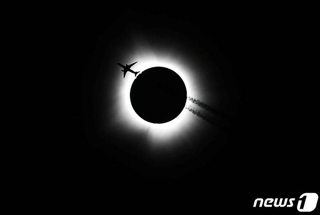 8일(현지시간) 인디애나 블루밍스턴 지역에서 한 비행기가 해를 품을 달을 지나가고 있다. ⓒ 로이터=뉴스1 ⓒ News1 박형기 기자