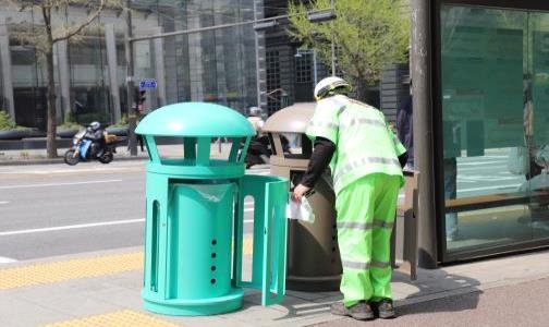 서울시 환경공무관이 일반형 가로 쓰레기통 앞에서 환경을 미화하고 있다. [사진 서울시]