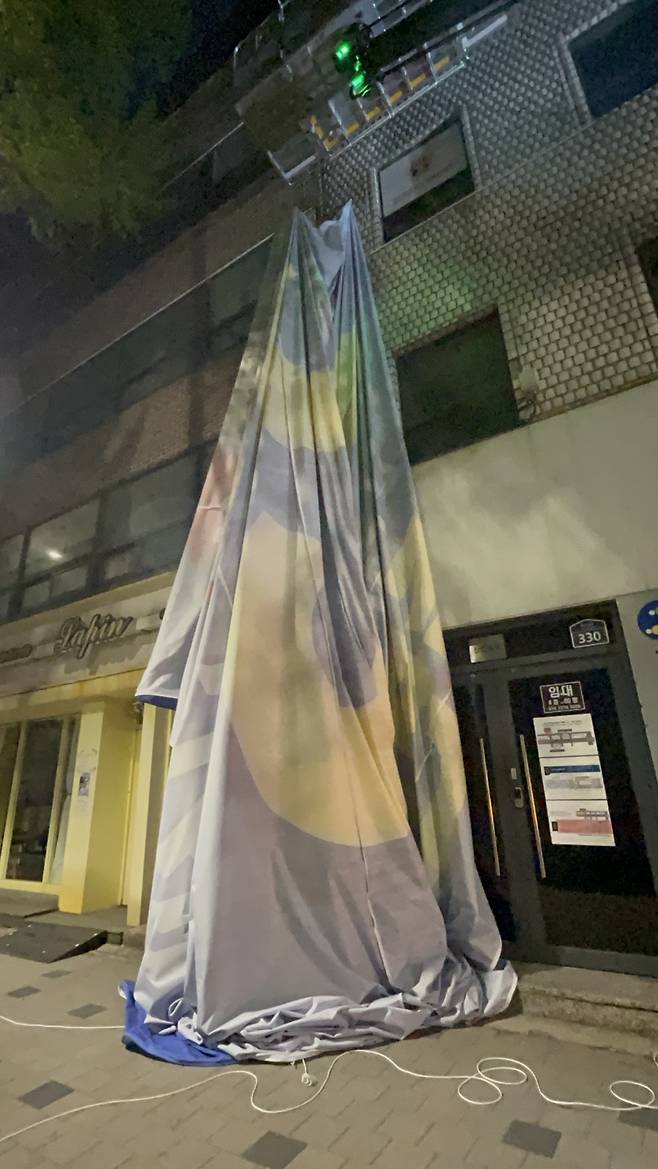 12일 오전 서울 용산구에서 건물에 걸린 대형 현수막을 철거하고 있다. 주소현 기자