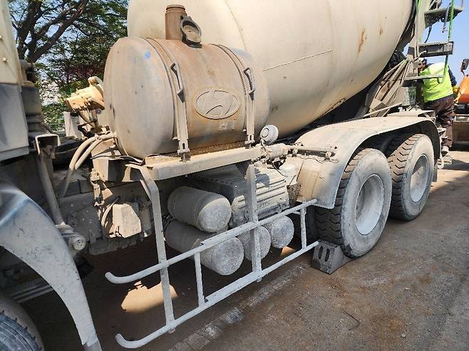 경사지에 정차한 레미콘 뒷바퀴 고임목이 불안정하게 지지돼(왼쪽) 한 현장 근로자가 작업중지권을 행사해 고임목이 정상 교체됐다(오른쪽).