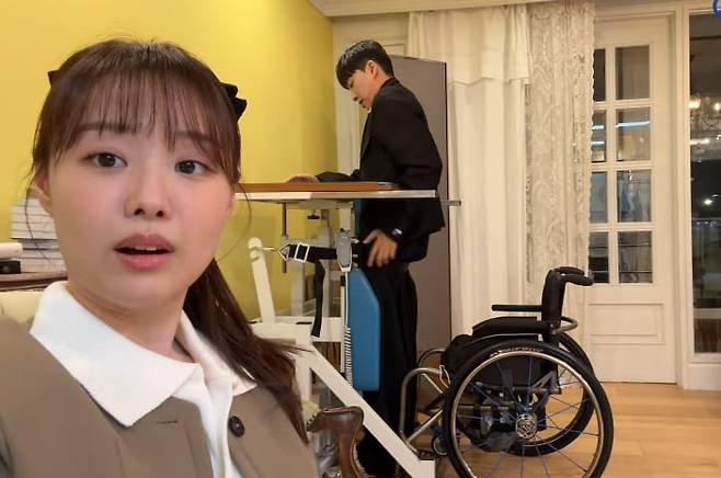 박위가 기구의 도움을 받아 휠체어에서 일어서는 재활운동을 하는 모습을 처음 본 송지은은 “설렌다”라며 감격했다. /유튜브 영상 캡처