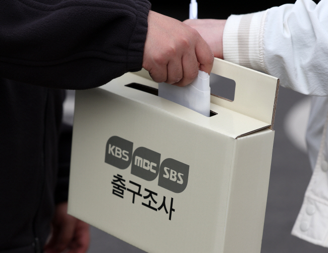 4·10 총선 당시 서울의 한 투표소에서 한 유권자가 투표를 마친 뒤 방송 3사의 출구조사에 응하고 있는 모습.  뉴시스