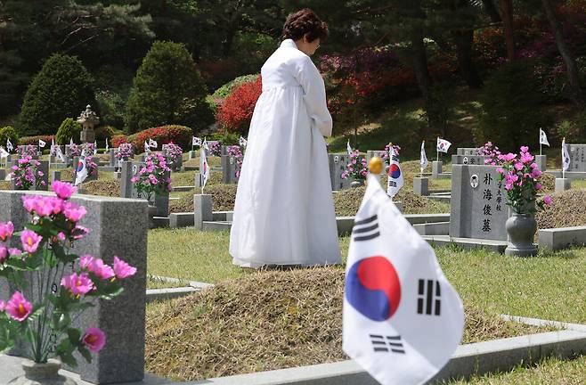이화자씨가 시위 중 구타당했던 남편 고 박해준씨의 묘 앞에서 묵념하고 있다. 김영원 기자