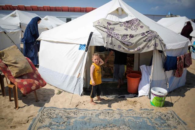 가자지구 남부 라파의 난민 캠프에서 한 어린이가 14일 텐트 밖을 바라보고 있다. 라파=AFP 연합뉴스