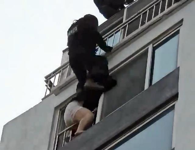 경찰특공대원이 옥상에서 로프를 타고 내려가 창문에 있던 A씨를 몸으로 밀쳐 실내로 들어가게 하고 있다. 연합뉴스