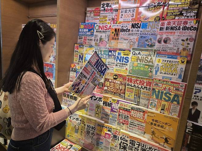 지난 14일 일본 도쿄 시부야구 다이칸야마에 있는 쓰타야 서점에서 한 시민이 ‘신(新)소액투자비과세제도(NISA)’에 대한 책을 읽고 있다.
