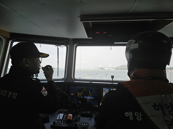 Choi Jae-ok, captain of a Mokpo Coast Guard patrol vessel, instructs the inspection squad to search a vessel off the coast of Mokpo on April 11.