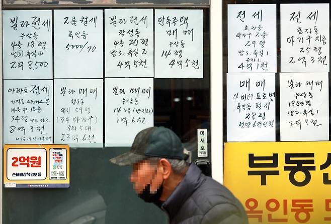 서울 한 부동산중개사무소 앞을 시민이 지나가고 있다.[연합]