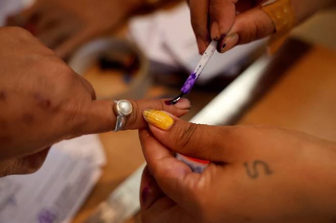 19일(현지시간) 인도 서벵골주 동부 알리푸르두아르 지역의 총선 1차 투표소에서 한 여성이 투표를 하기 전 손가락에 잉크를 묻히고 있다.(사진=로이터)