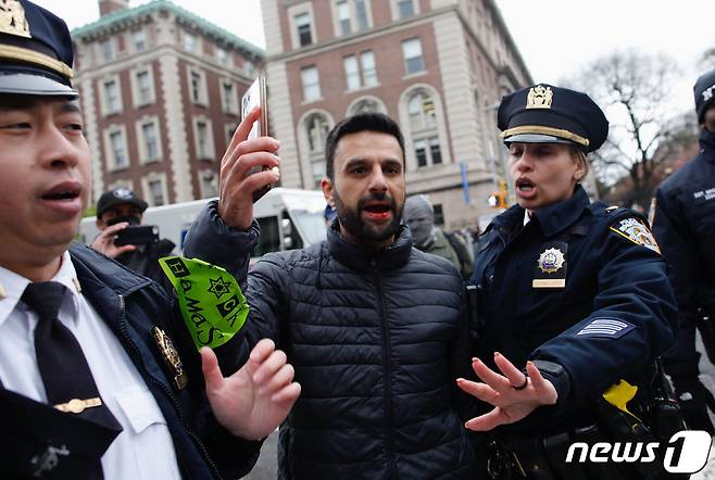 18일(현지시간) 미국 뉴욕 컬럼비아대학교 밖에서 친팔레스타인 시위대가 행진하자 경찰관이 한 남성을 연행하고 있다. 2024.04.18 ⓒ AFP=뉴스1 ⓒ News1 정지윤 기자