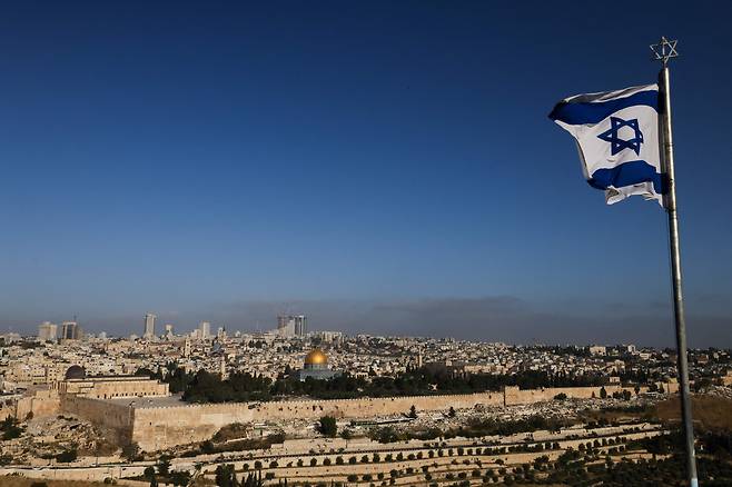 19일(현지 시각) 예루살렘의 알 아크사 사원 단지와 도시 스카이라인이 내려다보이는 올리브 산에 이스라엘 국기가 펄럭이고 있다. / AFP 연합뉴스