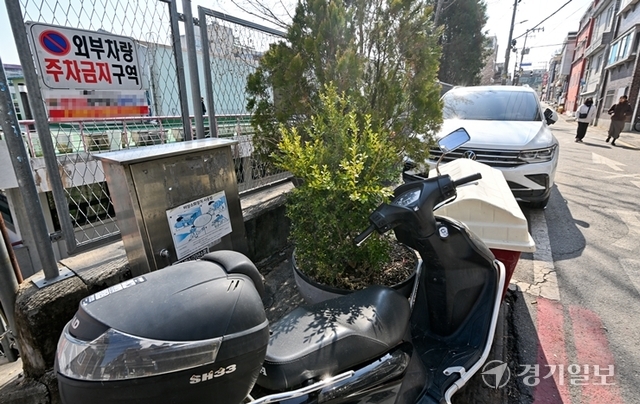 18일 오전 성남시 수정구 신흥동 주택가의 비상소화장치가 불법주차된 오토바이에 가려져 있다. 윤원규기자