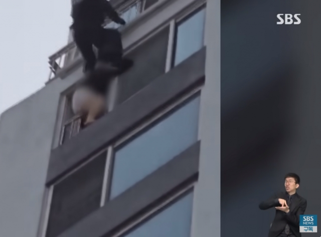 14층 창문에서 밖으로 다리를 내미는 여성을 제압하는 경찰특공대원. SBS 보도 캡처
