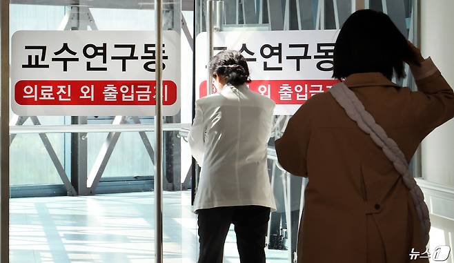 의대 교수들의 집단 사직 및 진료 축소 움직임이 가시화하고 있는 23일 오전 서울시내 한 대학병원에서 의료진이 교수연구동으로 발걸음을 옮기고 있다. 2024.4.23/뉴스1 ⓒ News1 이동해 기자