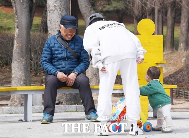 지난달 27일 오후 인천 남동구 인천대공원을 찾은 한 어르신이 나들이 나온 아기를 바라보며 미소 짓고 있다. /이새롬 기자