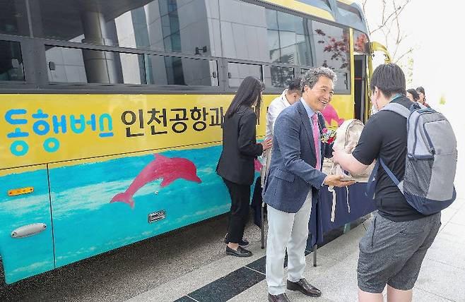 23일 인천공항 견학을 위해 동행버스에 오르는 청선학교 재학생이 이학재 인천국제공항공사 사장(오른쪽에서 두번째)으로부터 간식이 
들어 있는 가방을 받고 있다. 버스 외관은 발달장애가 있는 작가의 작품을 모티브로 디자인했다. 인천공항공사 제공