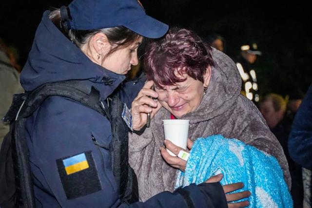 23일(현지시간) 우크라이나 오데사에서 러시아의 드론 공격을 받아 거주지가 파괴된 한 우크라이나 주민을 구조대원이 위로하고 있다. 오데사=AP 뉴시스