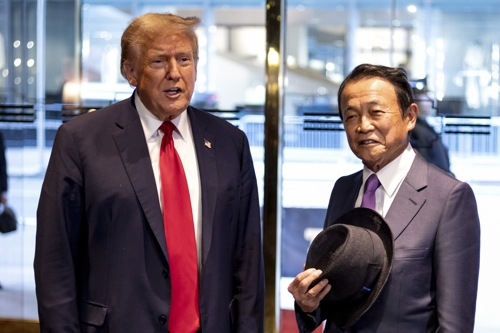 도널드 트럼프 전 미국 대통령이 23일(현지시간) 뉴욕 맨해튼의 트럼프타워를 찾은 아소 다로 전 일본 총리와 인사를 나누고 있다. AP연합뉴스