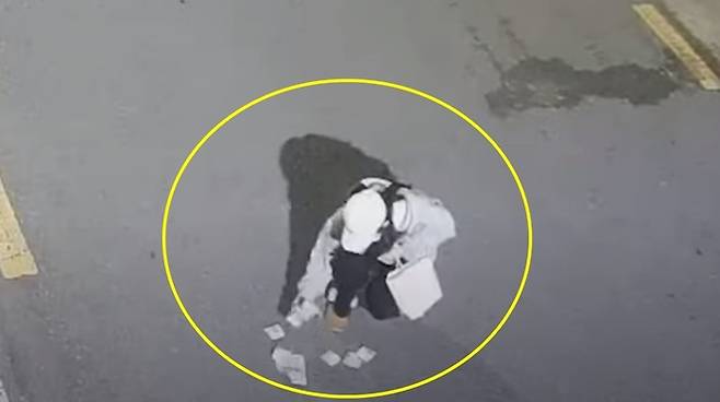 경남 하동군의 한 골목길에 떨어진 지폐를 줍는 여고생. [사진 = 유튜브 채널 ‘경찰청’ 캡처]