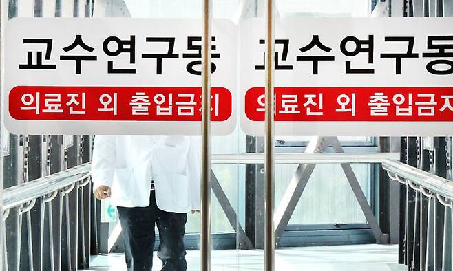 의대 교수들의 집단 사직 및 진료 축소 움직임이 가시화하고 있는 23일 오전 서울시내 한 대학병원에서 의료진이 교수연구동으로 발걸음을 옮기고 있다. 뉴스1