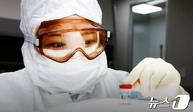 메디포스트 임직원이 바이오의약품이 담긴 유리병을 보고 있다.(메디포스트 제공)/뉴스1 ⓒ News1