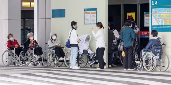 전국 주요 병원 교수들이 주 1회 외래 진료 휴진 등 진료 축소를 밝힌 가운데 24일 서울시내의 한 대학병원 응급의료센터 앞에 휠체어를 탄 환자들이 줄지어 진료를 기다리고 있다. [뉴스1]