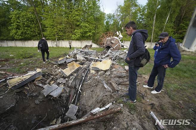 [하르키우=AP/뉴시스]지난 22일(현지시각) 우크라이나 하르키우 주민들이 러시아의 미사일 공격으로 절반가량이 파손된 TV 송전탑(240m) 잔해를 바라보고 있다. 2024.04.25.