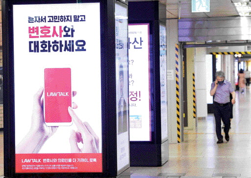 시민들이 서울 지하철 교대역에 걸린 로톡 광고판 앞을 지나가고 있다. 한경DB