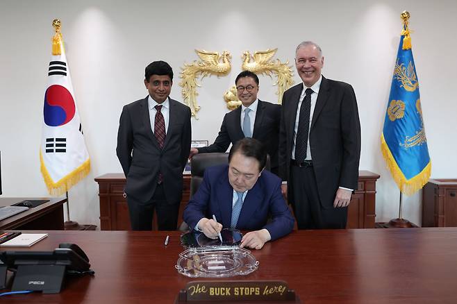 윤석열 대통령이 2022년 10월 7일 용산 대통령실에서 게리 디커슨 미국 어플라이드 머티어리얼즈(AMAT) CEO를 접견, 반도체 웨이퍼에 기념 서명을 하고 있다./대통령실